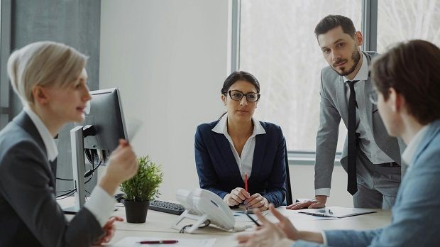 Vier Personen unterhalten sich im B&uuml;ro