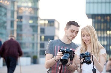 Zwei Personen, die sich ihre fotografischen Aufnahmen anschauen
