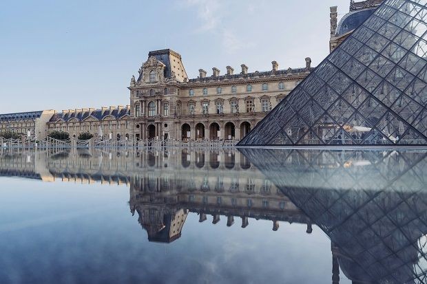 Louvre mit Spiegelung im Wasser