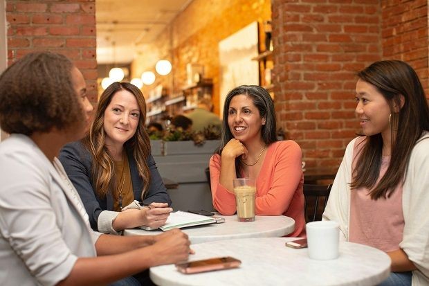 Vier Frauen im Cafe unterhalten sich
