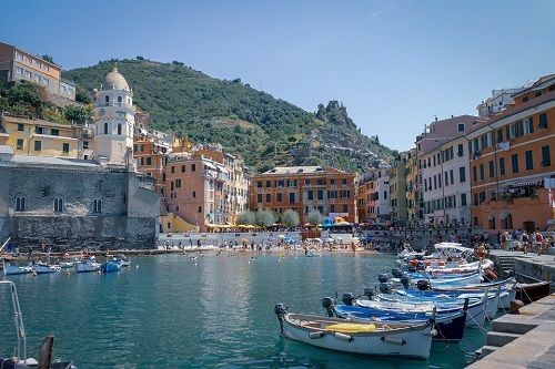 Kleine Bucht mit bunten Booten und mediterranen H&auml;usern im Hintergrund
