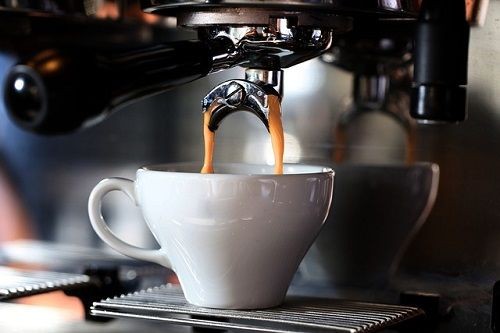 Ein Espresso, der aus einer Siebdruckmaschine in eine Espressotasse l&auml;uft