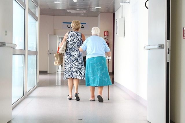 Eine Frau st&uuml;tzt eine &auml;ltere verletzte Frau mit Gehstock.