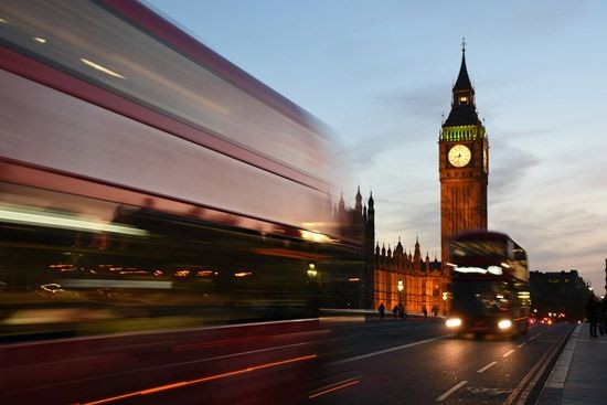 Big Ben in der Abendd&auml;mmerung mit vorbeifahrendem Bus