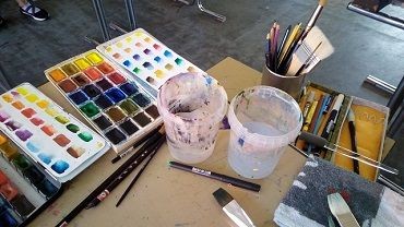 Tuschkasten mit Pinsel und Wasserbecher