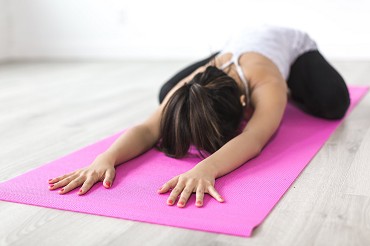 Person auf pinker Matte in Yoga-&Uuml;bung