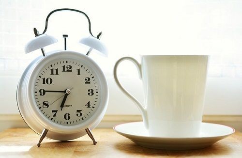 Eine Tasse Kaffee und ein Wecker