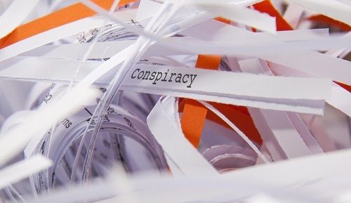 Mehrere Papierstreifen auf einem steht das Wort Conspiracy.