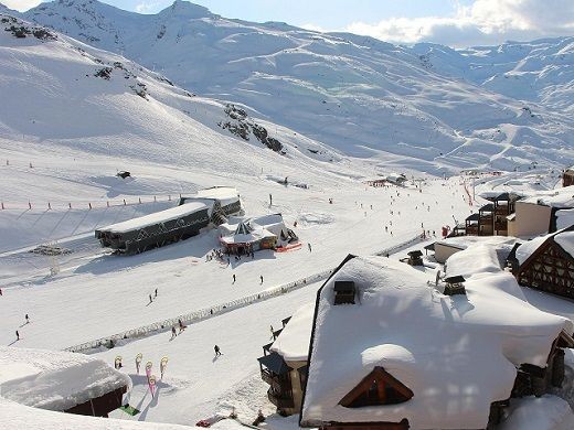 Ein sonniges Skigebiet mit verschneiten Bergen.