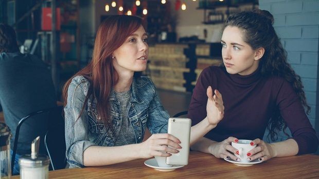 Zwei Frauen im Cafe reden miteinander