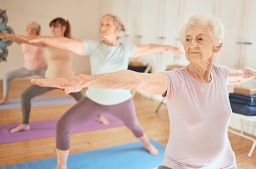 vier Frauen machen eine Yoga-Pose.