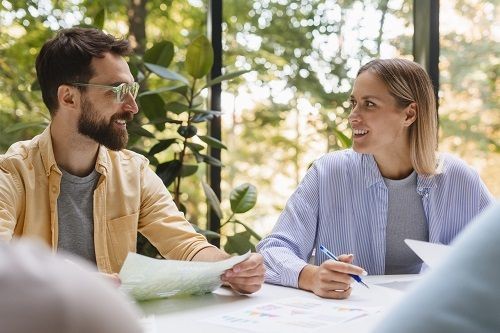 Zwei Personen unterhalten sich und l&ouml;sen Aufgaben