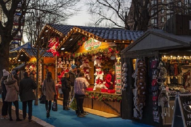 Weihnachtsmarktstand auf dem Braunschweiger Weihnachtsmarkt. Menschen vor einem Stand