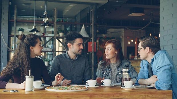 Vier Personen im Cafe unterhalten sich