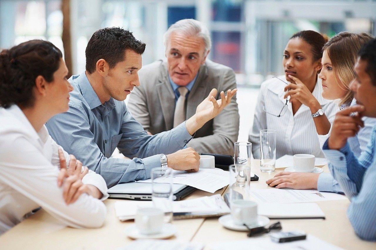 Gruppe von Menschen in einem B&uuml;ro an einem Meeting