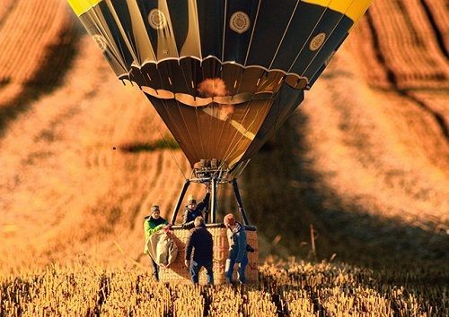 Menschen auf einem Feld neben einem Hei&szlig;luftballon