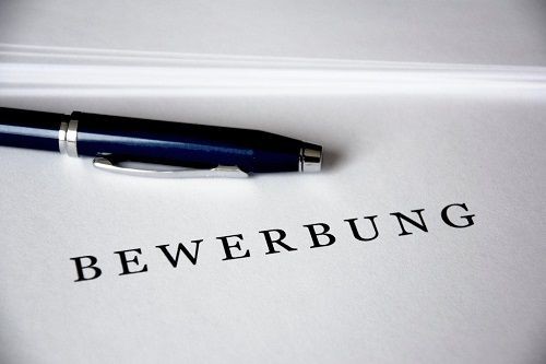 Blatt Papier mit Schriftzug BEWERBUNG und Stift