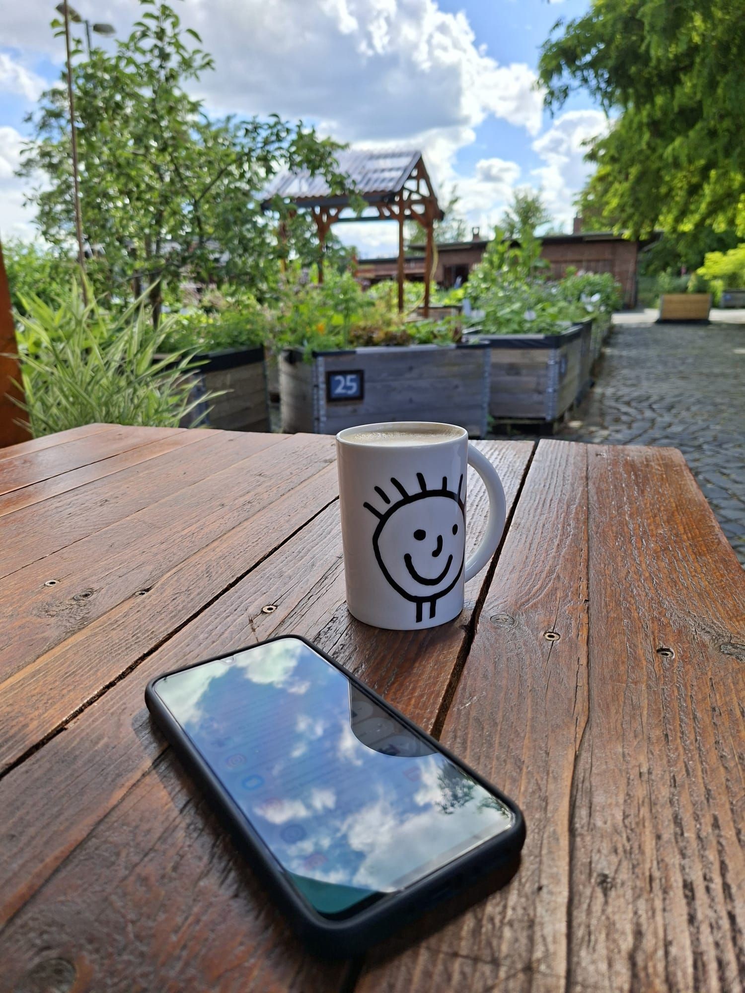 Mit dem Smartphone und einer Tasse Kaffee im Stadtgarten Bebelhof