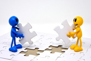 blaues und gelbes Männchen beim Puzzle