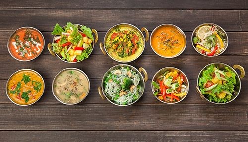 Schüsseln mit indischen Suppen und Salaten