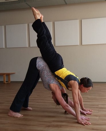 Zwei Personen machen eine Partner-Yogaübung